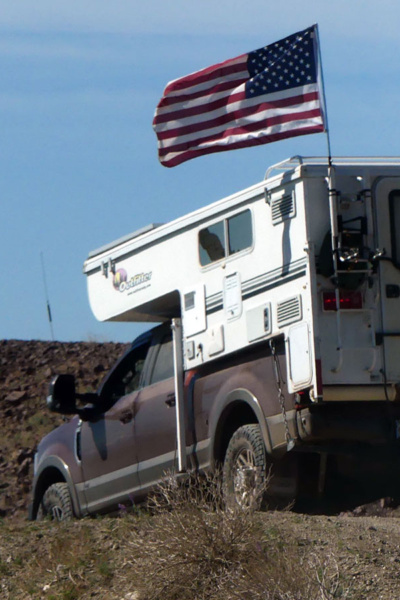 US flag flies over truck camper